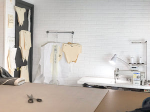 Who Makes Our Clothes image of the artists studio with sewing machines. The fashion design and production cut and sew factory.
